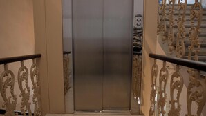 An elevator with a metallic finish, flanked by ornate, gold-colored railings. - Luxury b&b Villa Bellini: residential oasis 5 minutes from downtown (Catania)