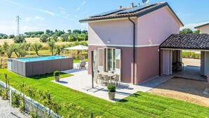 Ein modernes Haus mit Schwimmbad, Terrasse und Garten.
