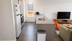 Et moderne køkken med indbygget ovn, vask og et vindue med udsigt.