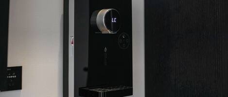 A black wall-mounted device with a circular dial and a small display.