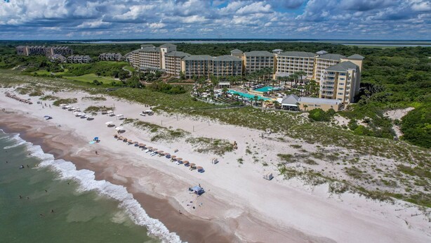 Een resort met meerdere gebouwen, een strand en een zwembad.