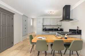 Una cocina moderna con armarios grises, una isla de madera y una campana extractora negra.
