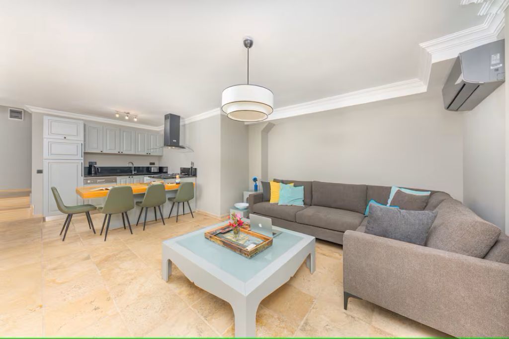 Un espacio moderno de estar con comedor, sofá y mesa de centro.