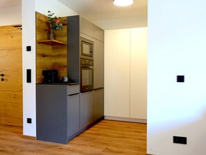 A compact kitchen with a built-in oven, microwave, and coffee machine. - Bergzeit Appartement Top 2 by Interhome (Saalbach-Hinterglemm)