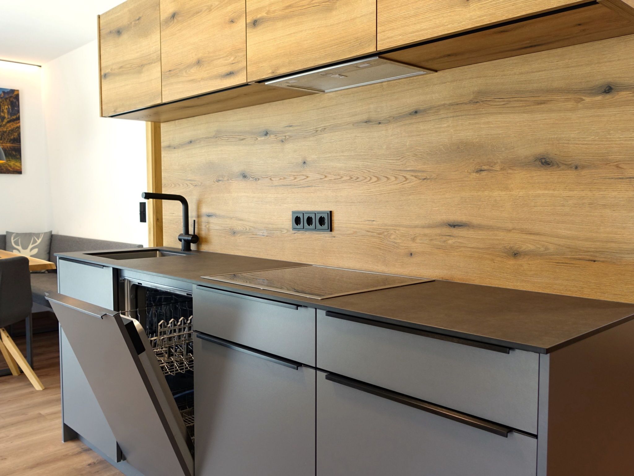 A modern kitchen with wooden cabinetry, a stainless steel sink, and a dishwasher.