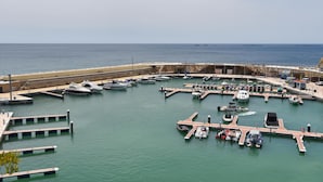 A marina with multiple docks and boats, a sandy beach, and a stone wall in the background. - Casa Timeris 8 pax - Calpe, Costa Blanca (Calpe)