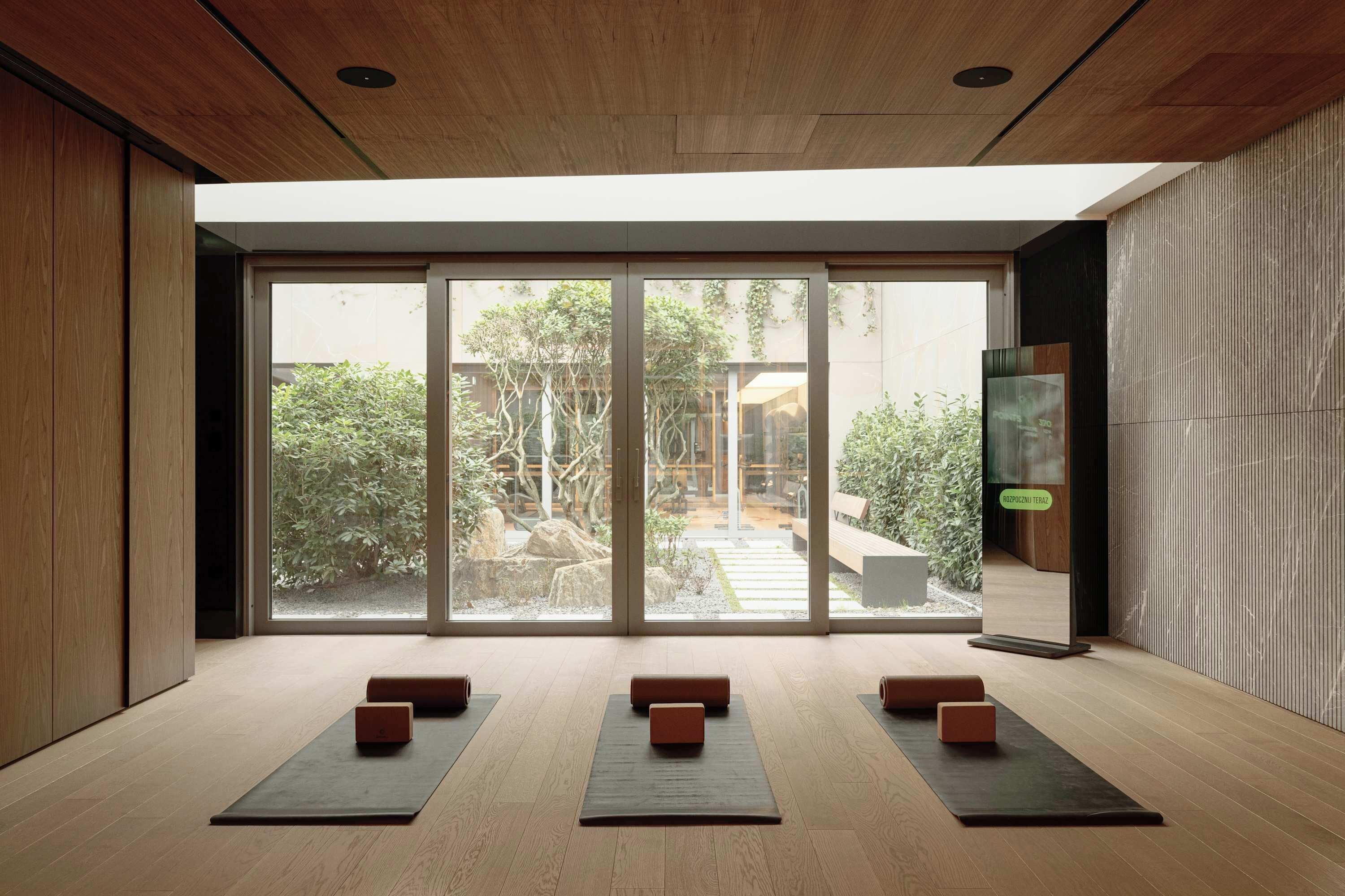 Amplia habitación con grandes puertas de vidrio correderas que dan a un jardín exterior.