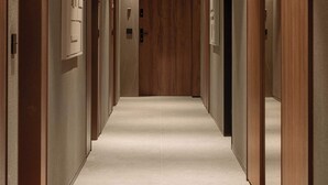 A corridor with wooden doors and a marble floor, leading to a room with a wooden door. - Modern Studio in the City Center Gym and Game Room (Katowice)