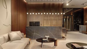 A modern lobby with a marble reception desk, a sofa, and a coffee table. - Modern Studio in the City Center Gym and Game Room (Katowice)