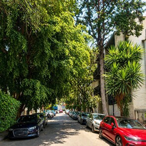 A tree-lined street with parked cars and buildings on either side. - Full house in Condesa, 4 bedrooms, terrace and 3 levels (Ciudad de México)