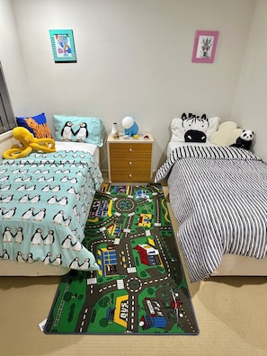 Une chambre avec deux lits, une table de chevet, une commode et un tapis.