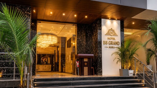 The entrance of Hotel BB Grand with marble steps and a grand chandelier.