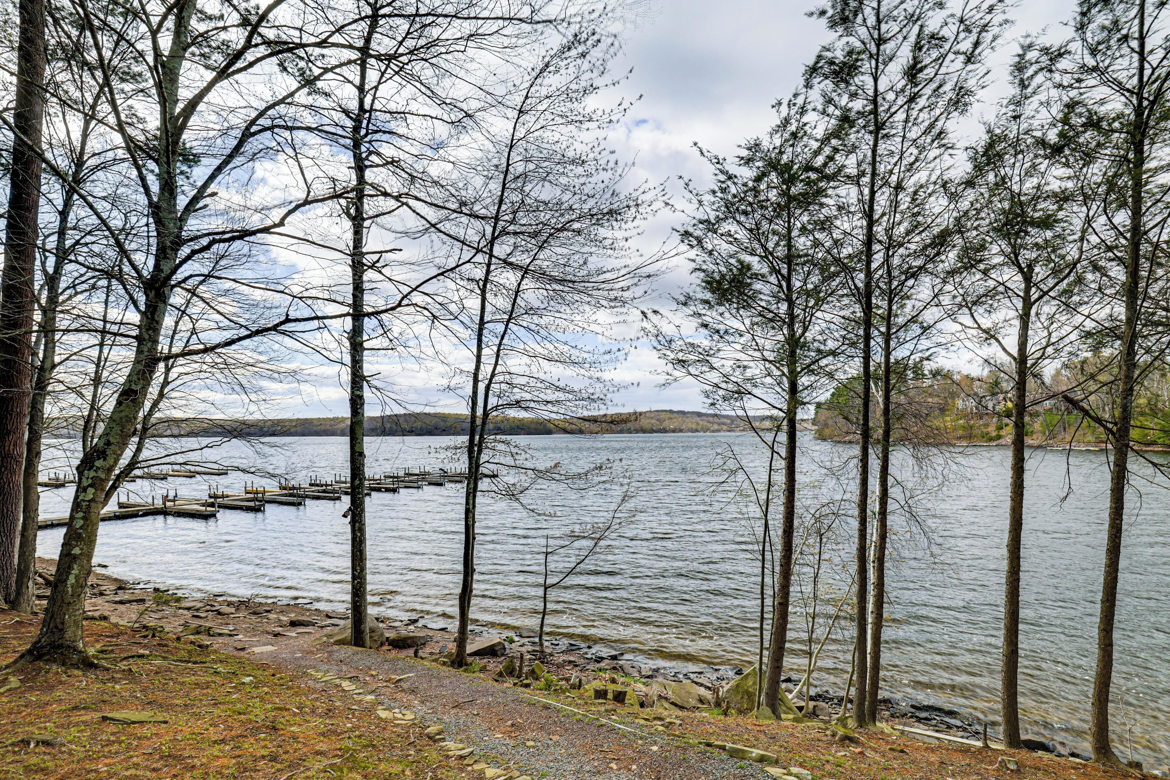 Une vue sur un lac, avec des arbres, un quai et une étendue d’eau calme.