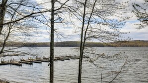 Un lac où sont amarrés des bateaux, avec des arbres et une rive visible au loin.