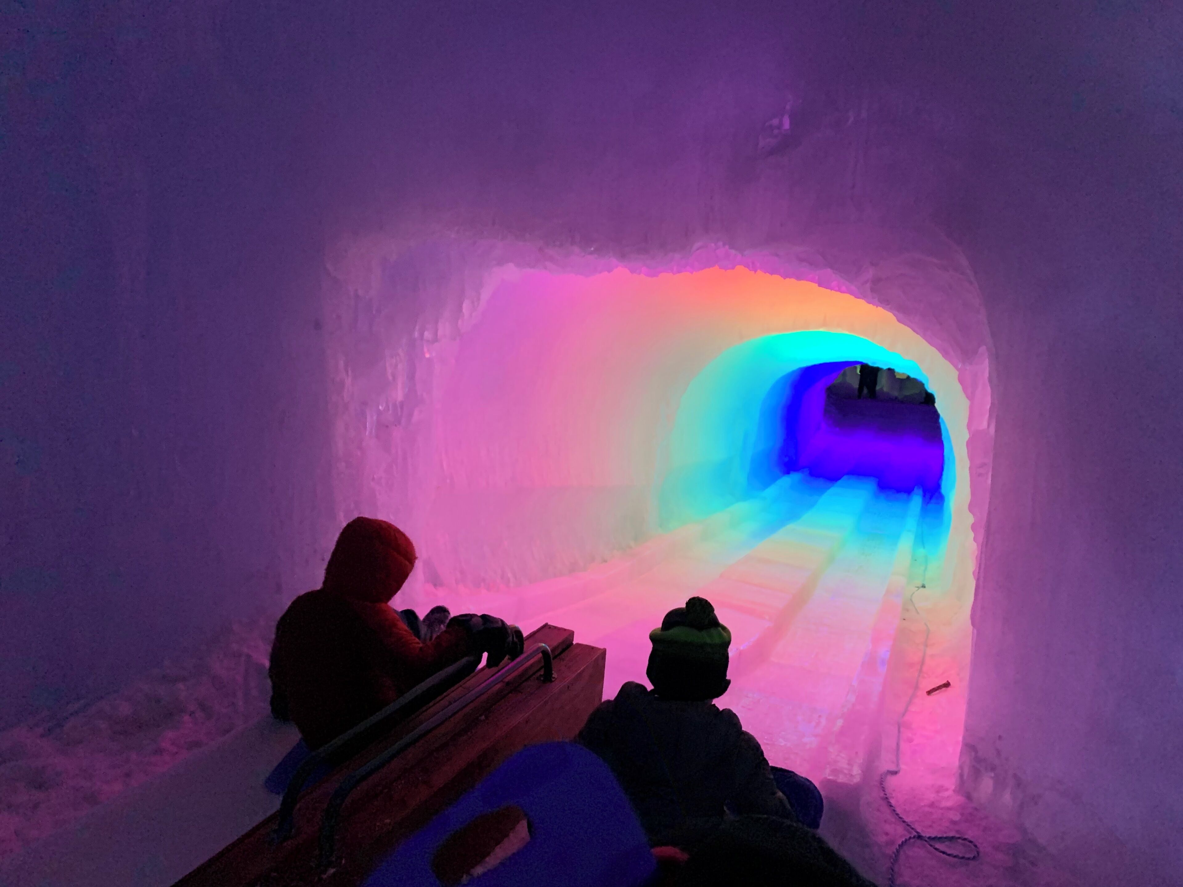 A snow tunnel with colorful lighting.