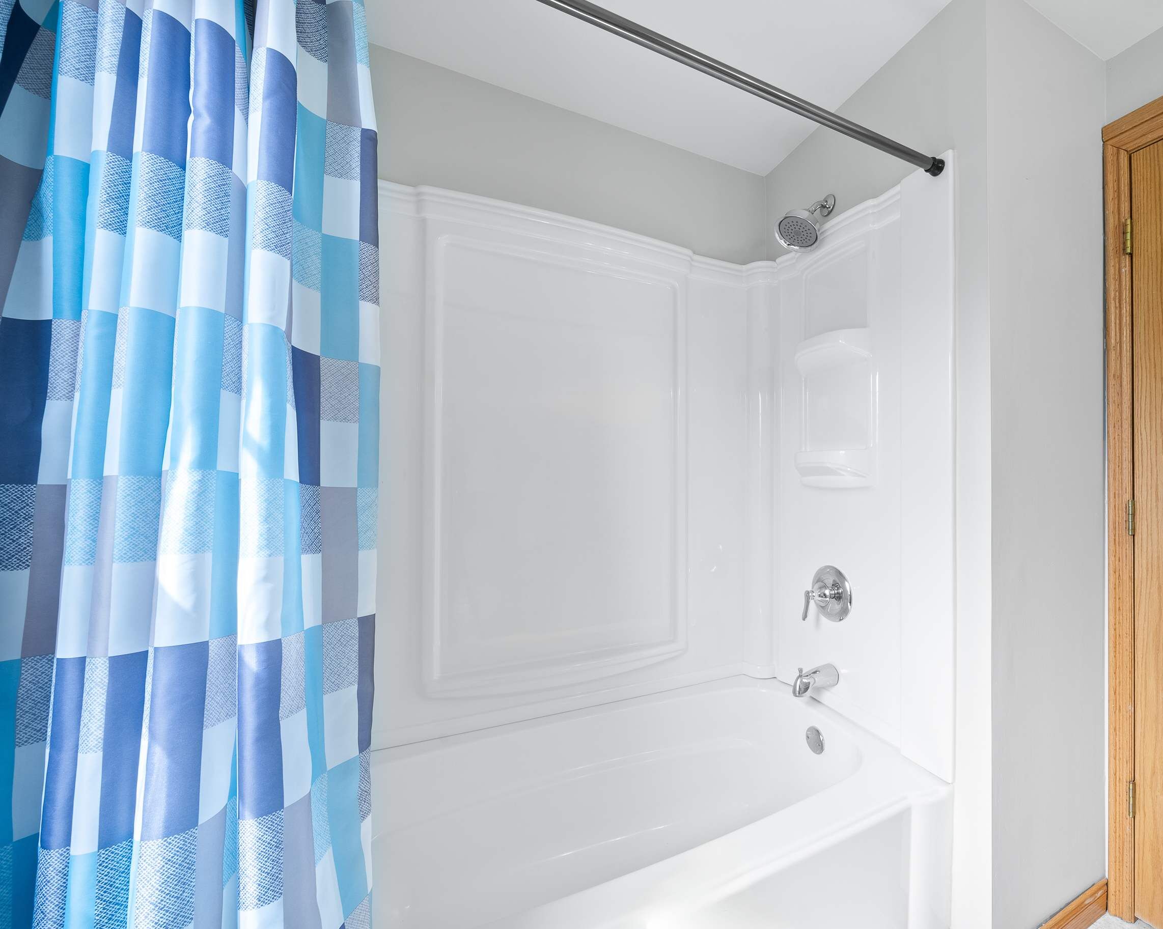 Une salle de bain équipée d’une douche, d’une baignoire et d’une porte en bois ornée d’un logo.