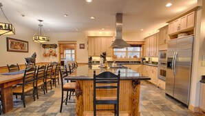 A spacious kitchen with a large island, wooden cabinets, and modern appliances. - Red Fir 14 (Bend)