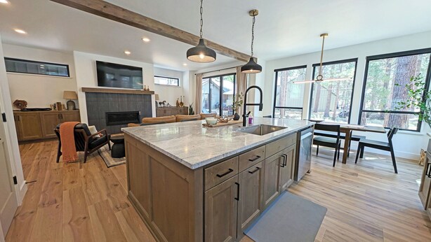 A spacious kitchen with a large island, wooden cabinets, and pendant lighting. - Pine Mountain 6 (Bend)