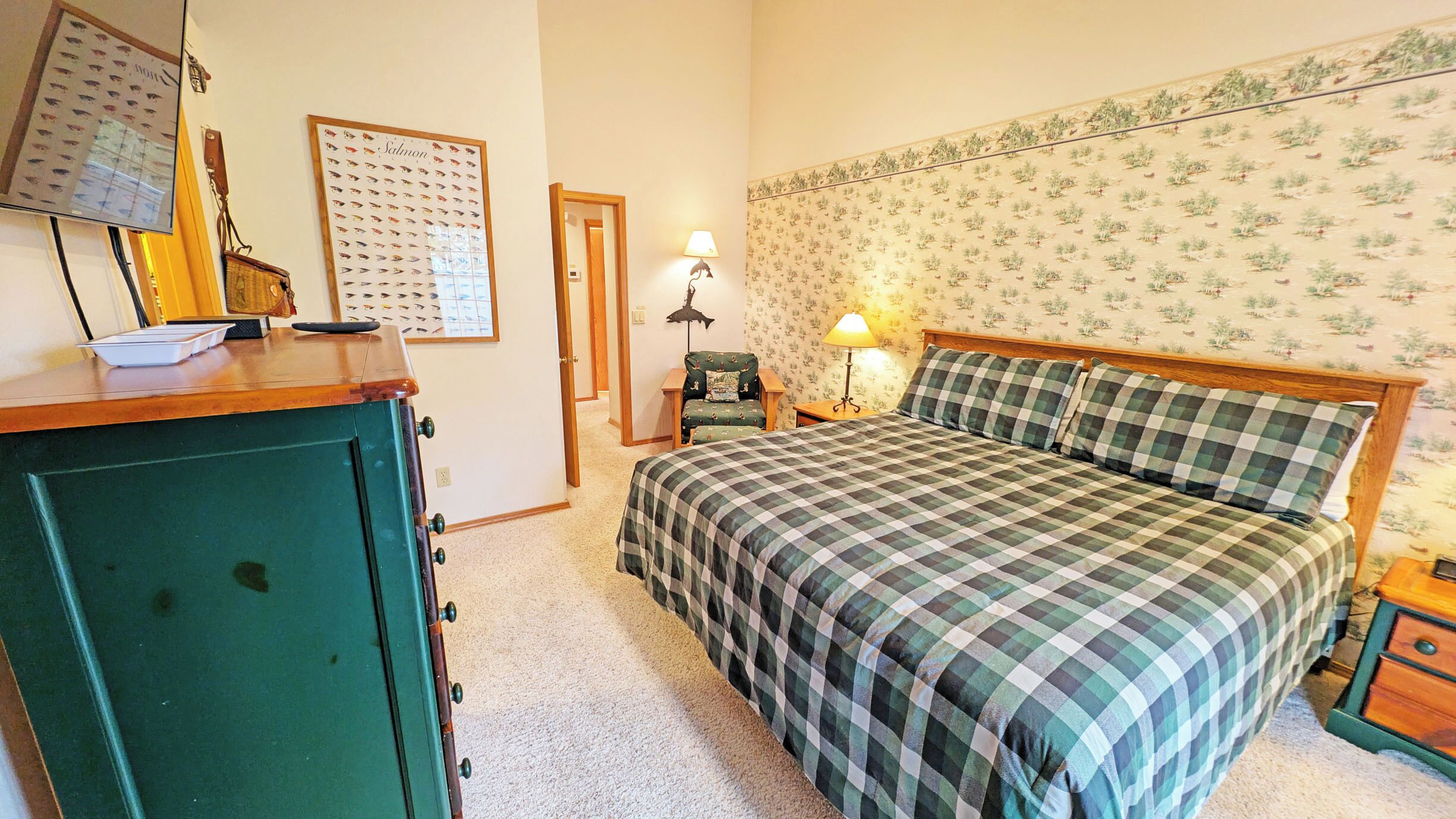 Une chambre à coucher avec un lit, une commode, une chaise et une lampe.