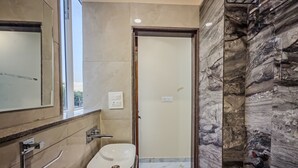 A bathroom with a sink, mirror, and a shower area. - Hotel Heaven Palace And Banquet (Jaipur)