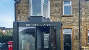 A building with a stone facade, a black entrance, and a sign reading 'The Old Post Office.' - 2 bedroom accommodation in Fence (Fence)