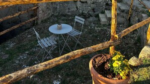 A rustic stone building with a balcony, outdoor seating, and a garden area. - La Tresa Country Living (Montepulciano)