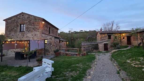 A stone building with a garden and outdoor seating area. - La Tresa Country Living (Montepulciano)