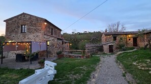 A stone building with a garden and outdoor seating area. - La Tresa Country Living (Montepulciano)