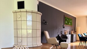 Uma sala de estar moderna com um sofá branco e azul curvo, uma mesa redonda e um abajur decorativo.