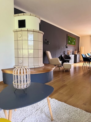 A modern living room with a curved white and blue sofa, a round table, and a decorative lamp. - Vacation home in Braunlage (Braunlage)