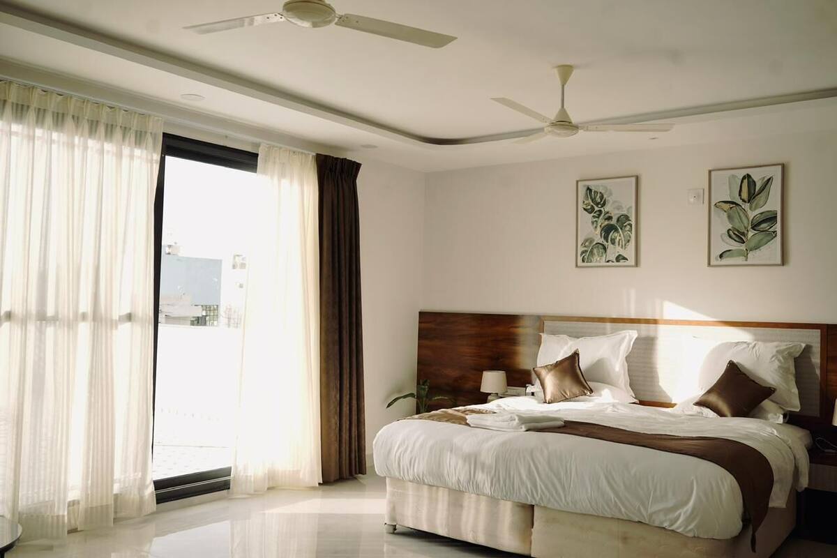 A bedroom with a bed, ceiling fans, and artwork on the walls.