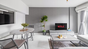 A modern living room with a dining area, a flat-screen TV, and a potted plant. - MEDIOFLAM 503 (Sapporo)