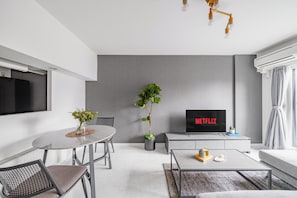 A modern living room with a dining area, a flat-screen TV, and a potted plant. - MEDIOFLAM 503 (Sapporo)