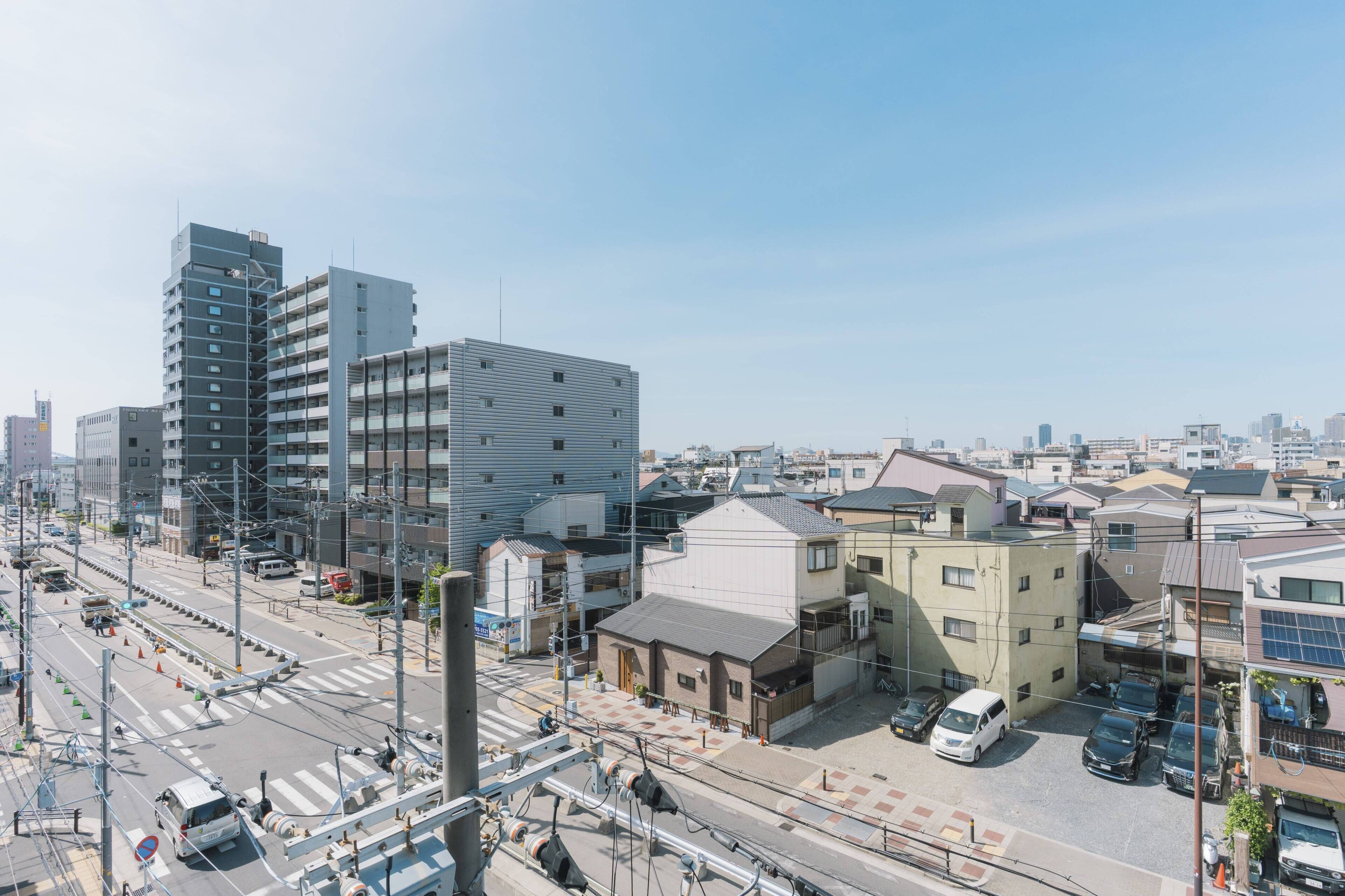 Une vue urbaine avec des bâtiments modernes, un passage piéton et des voitures garées.