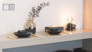 A modern kitchen with a light-colored countertop, a vase with branches, a bowl, a tissue box, and a light bulb. - b&Hanazono2 (Bainan, Nishinari Ward,)