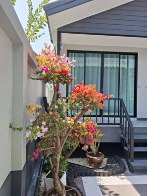 Un bâtiment moderne avec un escalier, un pot de fleurs aux couleurs vives et un ciel dégagé.