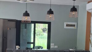 Una cucina moderna con isola in marmo, sedie in legno e luci a sospensione.