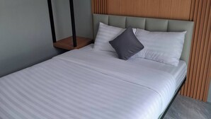 Una camera da letto moderna con un letto, una testiera in legno e un comodino.
