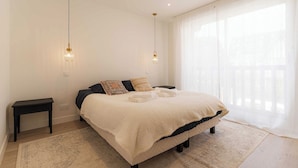 A bedroom with a bed, bedside tables, and a large window with sheer curtains. - Magnificent Apartment - 2br- 6P - Garden - Deauville (Deauville)