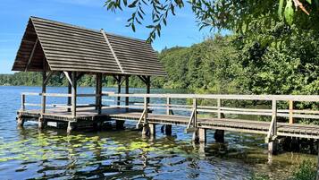 Une jetée en bois s’avançant dans un lac, avec un pavillon abrité.