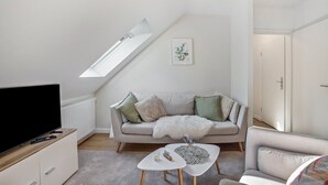 A modern living room with a television, sofa, and coffee table. - Nordic Stay Bäk: Private Terrace & Garden near Lake Ratzeburg, Lübeck, Mölln (Bäk)