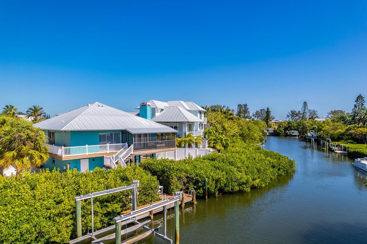 A waterfront property with a dock, a boat, and lush greenery.