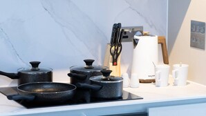 Eine Küche mit Herd, Töpfen, einer Kaffeemaschine und Salz- und Pfefferstreuern.