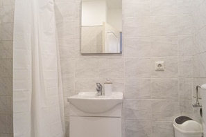 Ein Badezimmer mit Waschbecken, Spiegel und Duschvorhang.