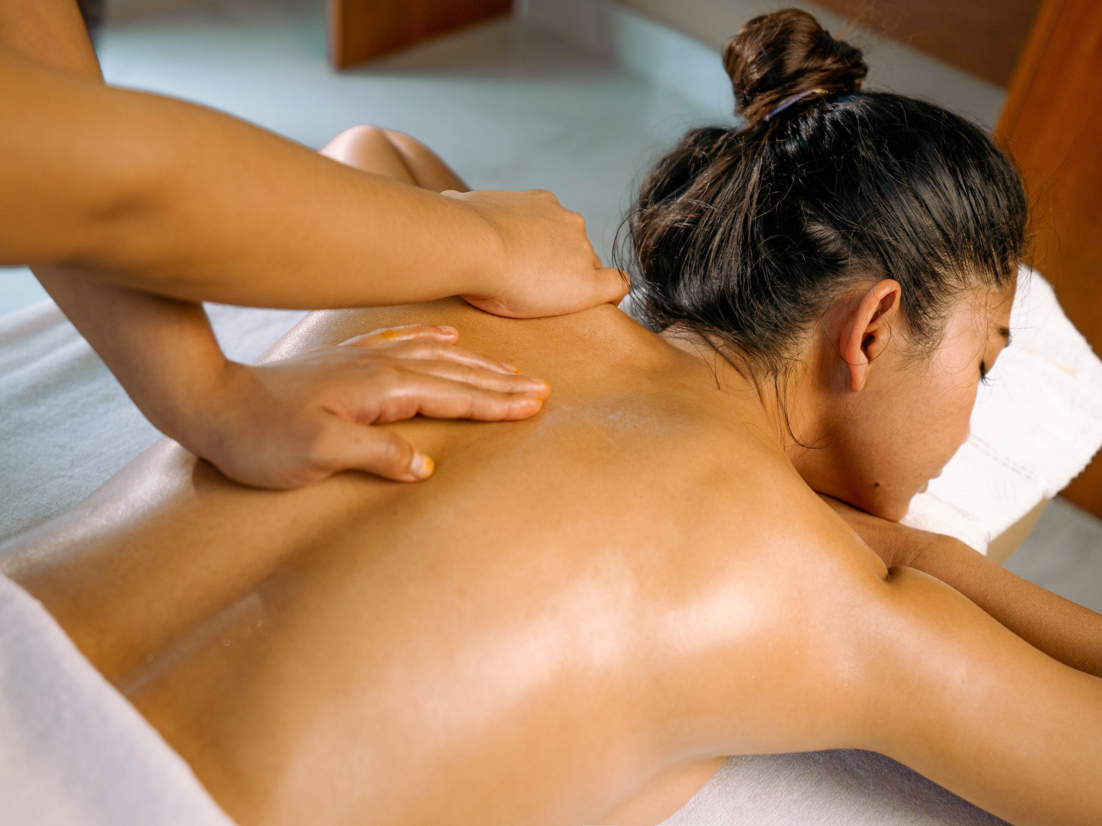 A person receiving a back massage on a massage table.