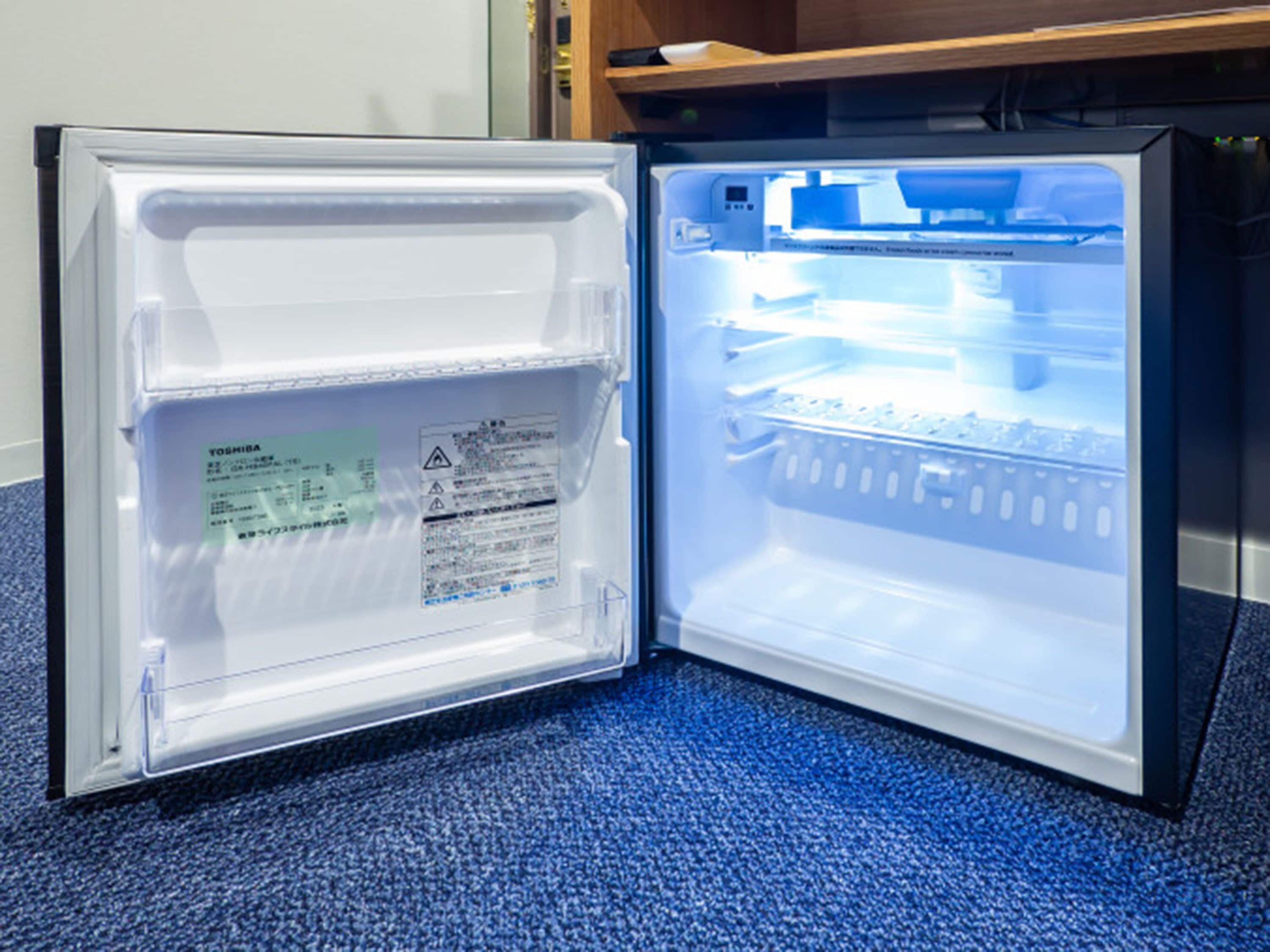 Ein offener Kühlschrank mit blauer Inneneinrichtung, einem Warnhinweis und einer Bedieneinheit.