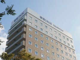 Un edificio a più piani con facciata piatta, molte finestre e indicazioni che si tratta di un hotel.