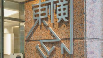 A wall with a large, metallic sign featuring stylized letters.