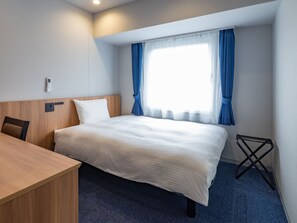 A hotel room with a bed, a desk, a chair, a window with curtains, and a small table. - Toyoko Inn Tsukuba-eki (Tsukuba)