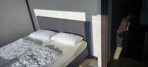 Ein Bett mit Kopfteil, Kissen und Decke.